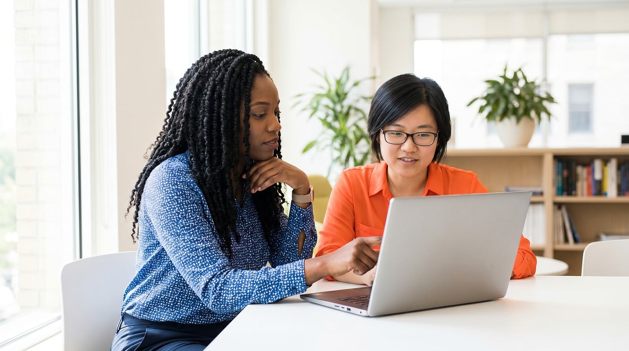 Two colleagues collaborating over a laptop